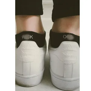 Funny black cotton ankle socks with letter embroidery worn with white sneakers back view