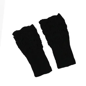 Detailed view of black knitted fingerless gloves featuring a hollow heart pattern texture