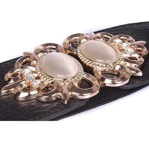 Ornate gold buckle with rhinestones on wide black elastic waist belt for dresses