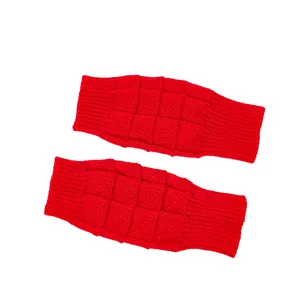 Close-up detail of red knitted fingerless gloves featuring soft waffle pattern texture
