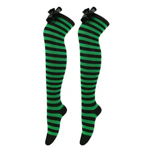 Detalle de calcetines altos a rayas verdes y negras con elegantes lazos de satén negro.