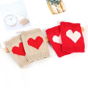 Gezellige gebreide beenwarmers met hartjespatroon in beige en felrode kleuren voor winter