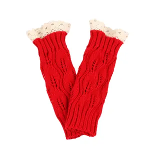 Detailed macro view of red knitted arm warmers featuring beige lace trim and leaf pattern