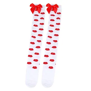 Detail of white over-the-knee socks featuring red lip prints and red satin bows