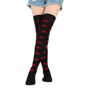 Close-up of black over-the-knee socks with vibrant red lip prints for Valentine's Day.