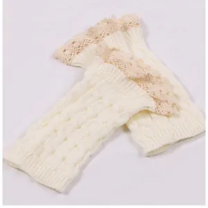 Macro view of white cable knit leg warmers featuring delicate cream lace trim details.