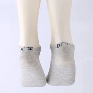 Close-up detail of grey low-cut socks featuring funny letter print on the heel rim