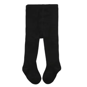 Close-up detail of solid black footed tights for infants and toddlers on a white background