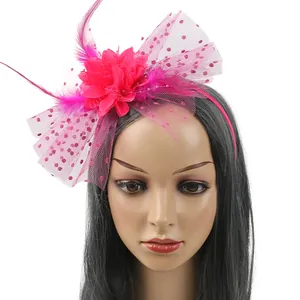 Detail of fuchsia fascinator headband with rose flower feathers and polka dot mesh veil.