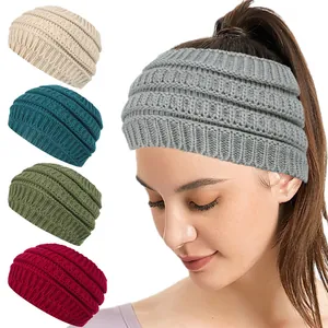 Assorted thick knitted winter headbands for women shown in five colors on model.