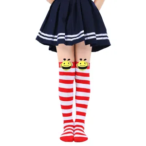 Close-up of red and white striped over-the-knee socks with cute bee plush dolls