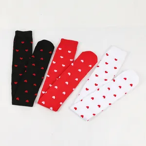 Detailed view of Valentine's Day over-the-knee socks in red, black, and white heart patterns