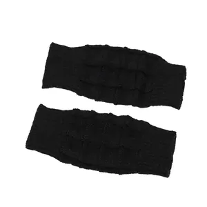 Close-up detail of black knitted fingerless gloves with a waffle texture pattern.