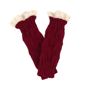Close-up detail of burgundy knit fingerless gloves featuring hollow leaf patterns.