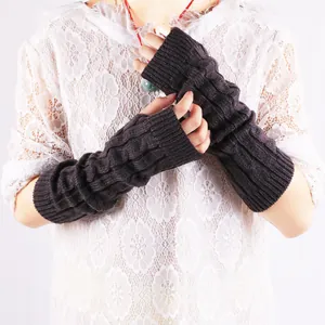 Detail of dark brown cable knit fingerless arm warmers with soft wool texture