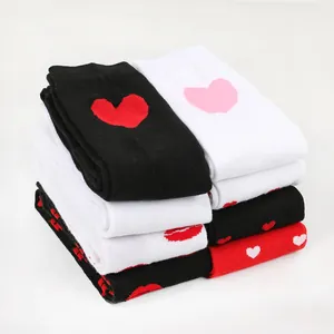Folded stack of Valentine's Day over-the-knee socks with heart and lip patterns
