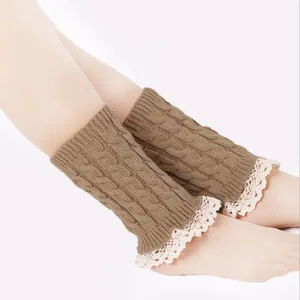 Detailed close-up of brown cable knit leg warmers featuring delicate white lace trim on feet