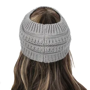 Vista trasera de un gorro de punto gris para cola de caballo con diseño de abertura superior