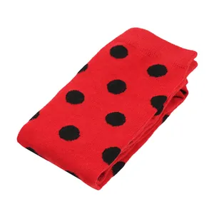 Detailed view of folded red ladybug stockings with black polka dots for kids holiday costumes