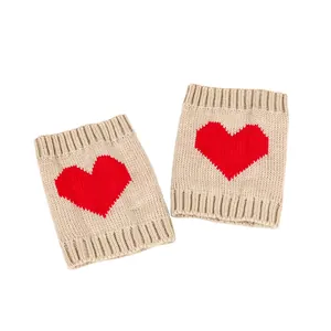 Gebreide beige beenwarmers met een rood hartpatroon en geribbelde randen detail.