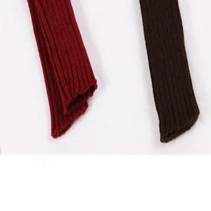 Close-up detail of burgundy and brown ribbed knitting texture on warm acrylic arm sleeves