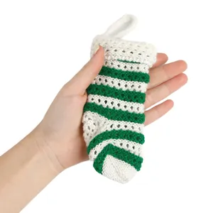 Nahaufnahme einer kleinen grün-weiß gestreiften gestrickten Weihnachtssocke in der Hand