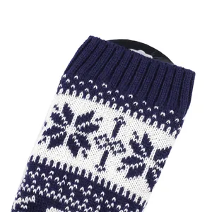 Dettaglio di scaldamuscoli invernali in maglia blu navy e bianchi con motivo a fiocchi