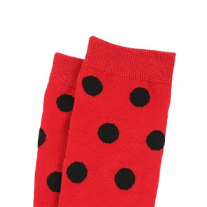 Macro detail view of red children's socks featuring a black ladybug polka dot pattern.
