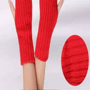 Close-up detail of red ribbed knitted arm warmers showing the soft acrylic fabric texture.