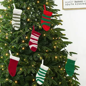 Sortiment kleiner gestrickter Weihnachtssocken als festliche Ornamente am Weihnachtsbaum.