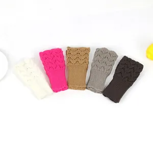 Macro view of heart-shaped crochet knit fingerless gloves in five different colors.