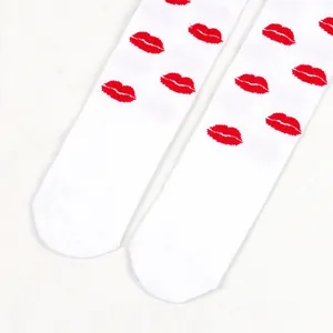Close-up of white over-the-knee socks with vibrant red lip pattern for Valentine's Day.