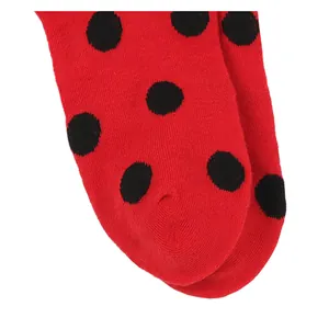 Close-up detail showing the knitted texture of red and black polka dot ladybug socks