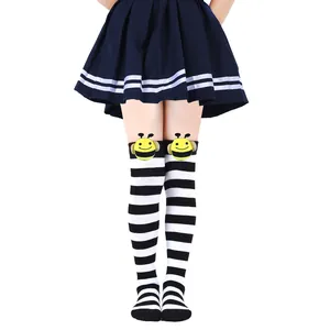 Close-up of children's black and white striped over-the-knee socks with bee plush