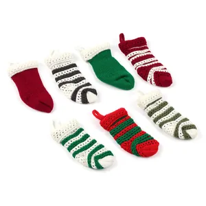 Kleine gestrickte Weihnachtssocken in verschiedenen festlichen Farben und Mustern
