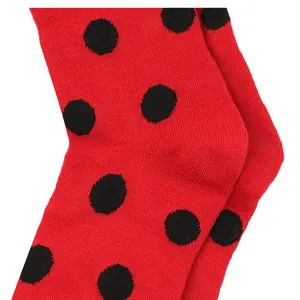 Detailed macro view of ladybug-themed red children's socks with black polka dot pattern
