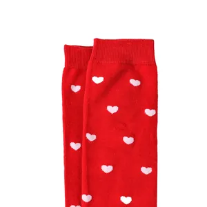 Close-up of red over-the-knee socks with pink heart patterns for Valentine's Day
