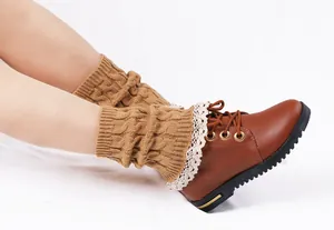 Detailed view of brown cable-knit leg warmers featuring delicate white lace trim accents