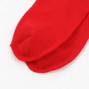 Detailed macro view of the reinforced toe seam on a vibrant red knitted sock