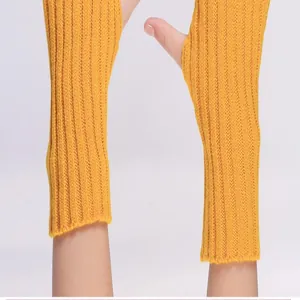Detailed close-up of yellow ribbed knitted fingerless arm warmers with thumb holes.