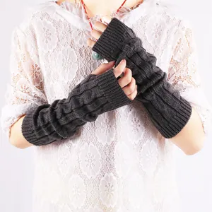 Close-up of dark grey cable knit fingerless arm warmers showing thick warm texture