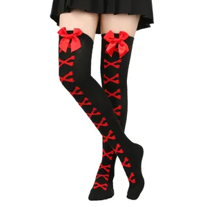 Détail de chaussettes hautes Lolita noires avec nœuds rouges et motifs d'os pour cosplay