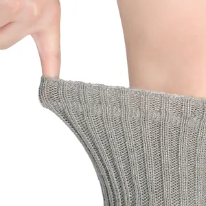 Gros plan d'une jambière en tricot gris de 50 cm montrant son élasticité et sa texture côtelée.