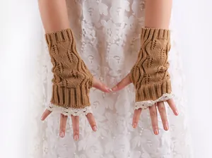 Close-up of elegant camel knitted fingerless gloves featuring delicate white lace trim detail.