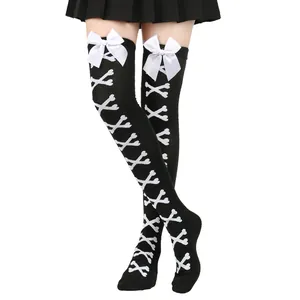 Détail de chaussettes hautes noires avec motifs d'os blancs et nœuds décoratifs