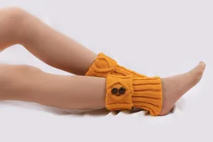 Detailansicht orangefarbene Strickstulpen mit braunen Knöpfen und Rippenmuster