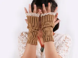 Macro view of knitted fingerless gloves with lace trim and intricate patterns.