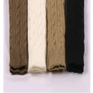 Detailopname van gebreide armwarmers met kabelpatroon in vier kleuren voor de koude winter