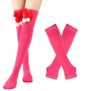 Detailansicht der pinken Weihnachts-Kniestrümpfe mit roten Schleifen und Bommeln.