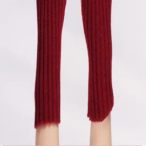 Close-up of burgundy knitted arm warmers featuring a ribbed texture and soft cuff design.